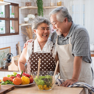 老人健康摄影照片_年长的夫妇在厨房与健康食品-退休的人与男人和女人准备午饭与生物蔬菜烹饪到家里吃饭-快乐老人概念与成熟有趣的养老金领取者开心.