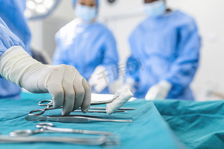 护士手外科医生在背景作业在外科手术室病人组采取外科手术器械。钢的医疗仪器随时可以使用。外科手术和紧急的概念