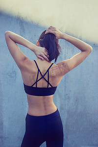 肌肉背对镜头穿运动胸罩和瑜伽裤