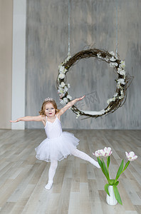 穿着白色芭蕾服装的可爱小芭蕾舞演员正在房间里跳舞。舞蹈课上的孩子儿童女孩正在学习芭蕾.