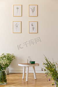 在起居室的白色墙上贴着鲜花和木桌的海报。真实照片