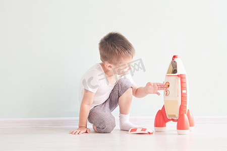 幼儿摄影照片_活泼的小男孩玩火箭玩具, 孩子显示火箭玩具与愉快的面孔, 孩子或幼儿学习和发展概念