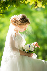 美丽的年轻新娘在白色婚纱礼服摆姿势 