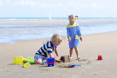 孩子们玩水和沙子在夏季
