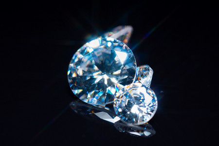 切割和抛光的钻石有选择地集中在黑色光滑的桌子上。奢侈的宝石收藏。晶莹晶莹的宝石钻石，圆圆的，大小不同。展示和检查.