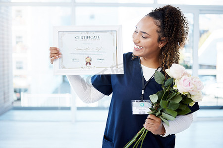 证书、鲜花和一名黑人妇女毕业于医院，为自己的成就感到自豪。一个快乐的年轻女护士独自站在诊所，她的笑容、毕业和资质.