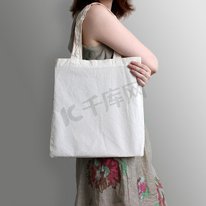 女孩拿着空棉花生态手提袋，设计样机.