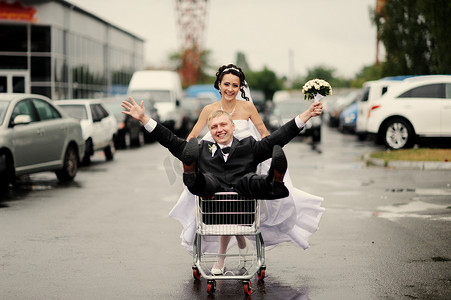 幸福的新娘拉的未婚夫在手推车