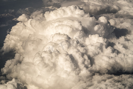 关闭照片看着一个大蓬松的白色块状和颠簸的积云从天上的一个平面窗口在蓝天