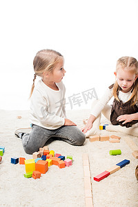 可爱的孩子们在白色的地毯上玩方块