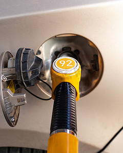 燃料泵摄影照片_在储气罐中插入燃料泵. 用汽油给客车加油. 92号汽油的黄色燃油泵，垂直特写