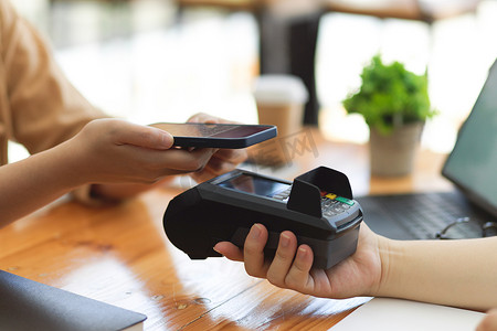 在咖啡店付款终端上使用智能手机扫描QR码、网上支付、现金交易等方式支付酒费的客户