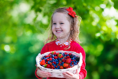 儿童采摘摄影照片_Little girl with fresh berries in a basket