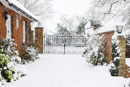 维多利亚时代的房子的入口与铸铁门与车道覆盖在冬季雪