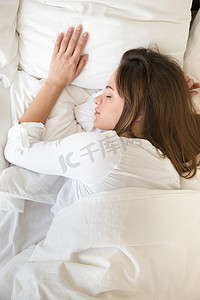 平静的年轻女性睡在床上的最高视图