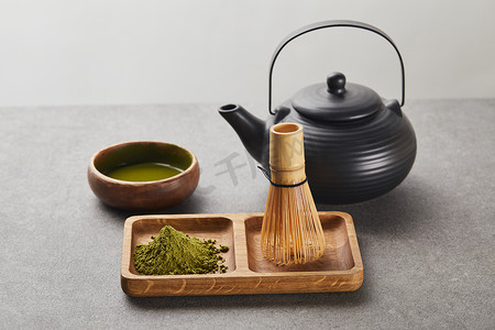绿火柴粉和竹须在木板上靠近红茶壶和碗与茶