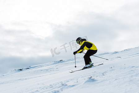 冬季戴头盔和护目镜在斜坡上滑雪的运动员 