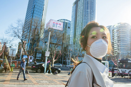 青年女人戴口罩在户外行走