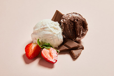 白色冰淇淋球摄影照片_新鲜美味的白色和巧克力冰淇淋球，带有薄荷糖和草莓粉背景