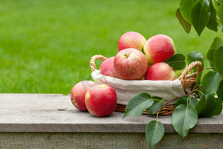室外木制桌子上的篮子里有成熟的花园苹果果，有复制空间
