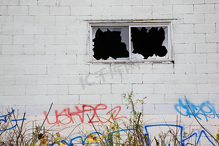 涂鸦摄影照片_破碎的窗户和涂鸦的建筑