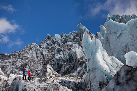 冰川运动摄影照片_欣赏冰川景观的徒步旅行者