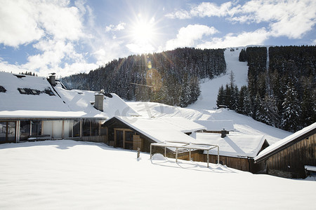 蓝天雪地摄影照片_滑雪坡道前的雪地度假小屋蒂罗尔奥地利