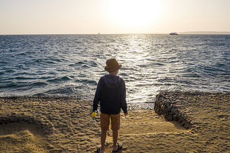 埃及红海赫尔加达小男孩站在海边仰望后方的景色