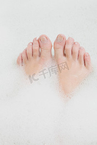 人类的脚摄影照片_女人泡泡浴中的脚