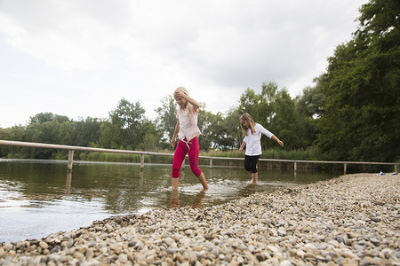两个女孩在乡村湖中划水