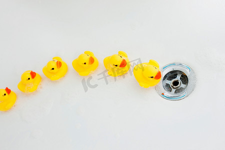 黄狮鱼摄影照片_橡胶鸭子向浴缸的排水孔移动
