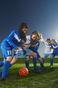踢足球的运动员摄影照片_踢足球的年轻女子