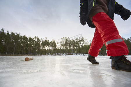 瑞典加夫勒男孩在结冰的湖面上行走的腰部以下的景色