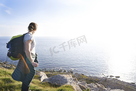 英国波特兰背着背包在悬崖上看海景的徒步旅行者