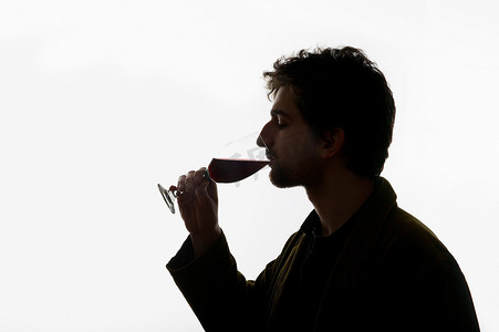 一个男人喝着一杯葡萄酒