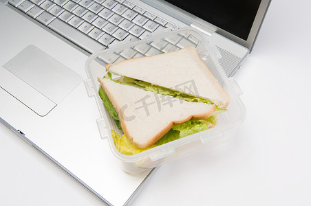 一个三明治和一台笔记本电脑