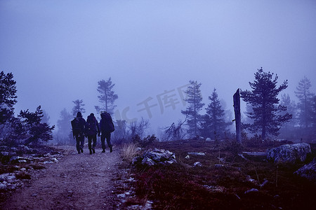 芬兰拉普兰徒步旅行者在黄昏穿越岩石田野