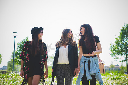 三个年轻的女性朋友在公园散步时聊天