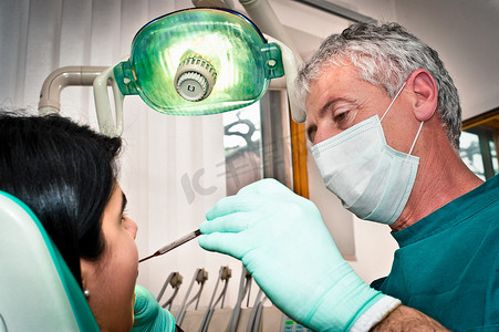 儿童口罩摄影照片_牙医在办公室为病人工作