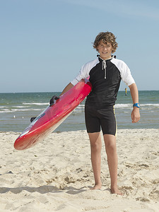 澳大利亚墨尔本阿尔托纳十几岁男孩尼珀儿童冲浪救生员背着冲浪板的肖像