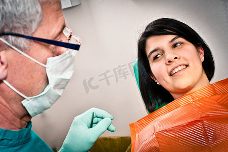 围围巾摄影照片_牙医和病人在办公室里交谈