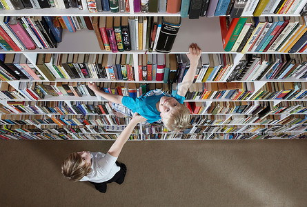 女孩帮男孩爬书架