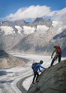 一对夫妇在瑞士瓦利斯的阿莱奇冰川上攀登山脊