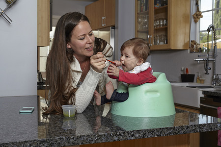 母亲在厨房柜台上给女婴喂奶