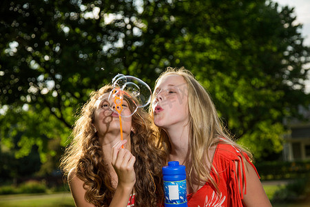 两个女孩用泡泡棒吹泡泡