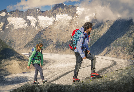 背景攀登摄影照片_一对夫妇在瑞士瓦利斯的阿莱奇冰川上攀登山脊