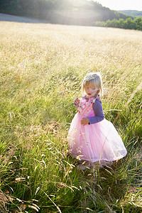 田野乡村人物摄影照片_打扮成公主的女孩在田野里