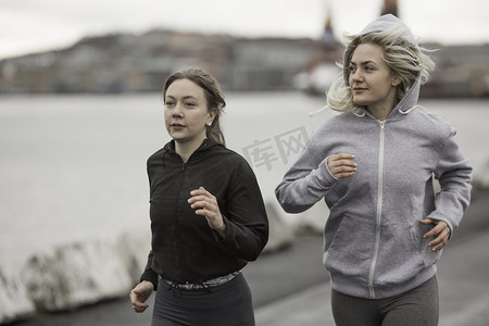 运动裤女摄影照片_两位女跑友在码头边跑步