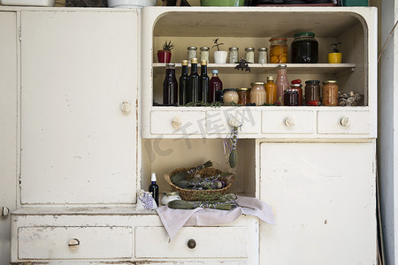 在复古风格的厨房橱柜上摆放着瓶瓶罐罐的自制食物