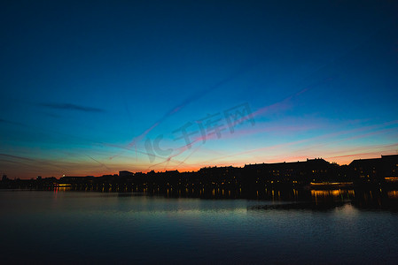 落日流水摄影照片_丹麦哥本哈根河滨的落日剪影